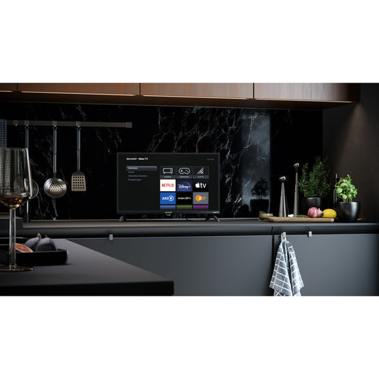 Sharp 24GD2225E im Wohnraum mit Roku TV Startbildschirm